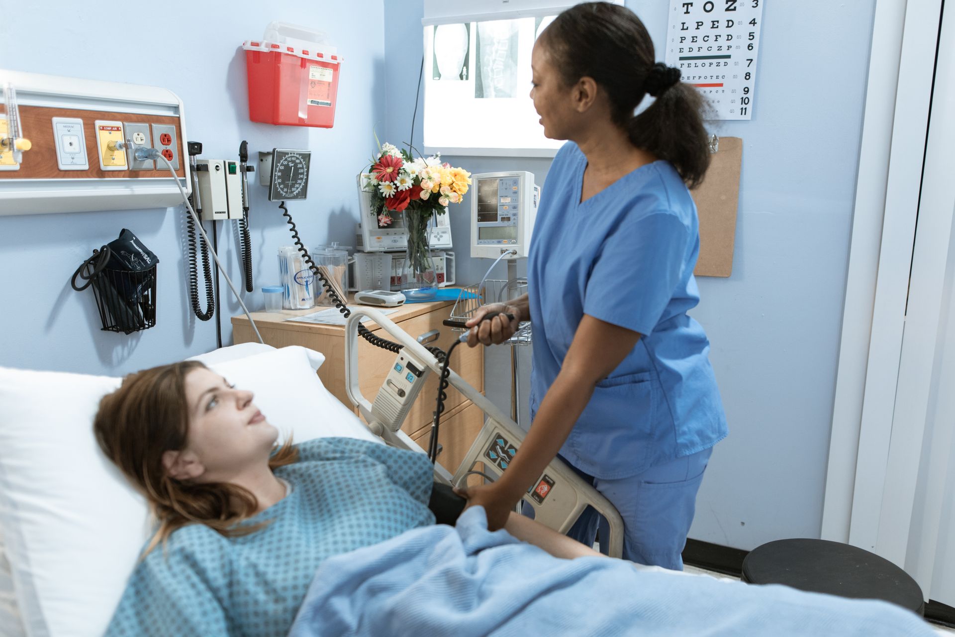 Nurse caring for a patient resting in a hospital bed during recovery after kidney surgery
