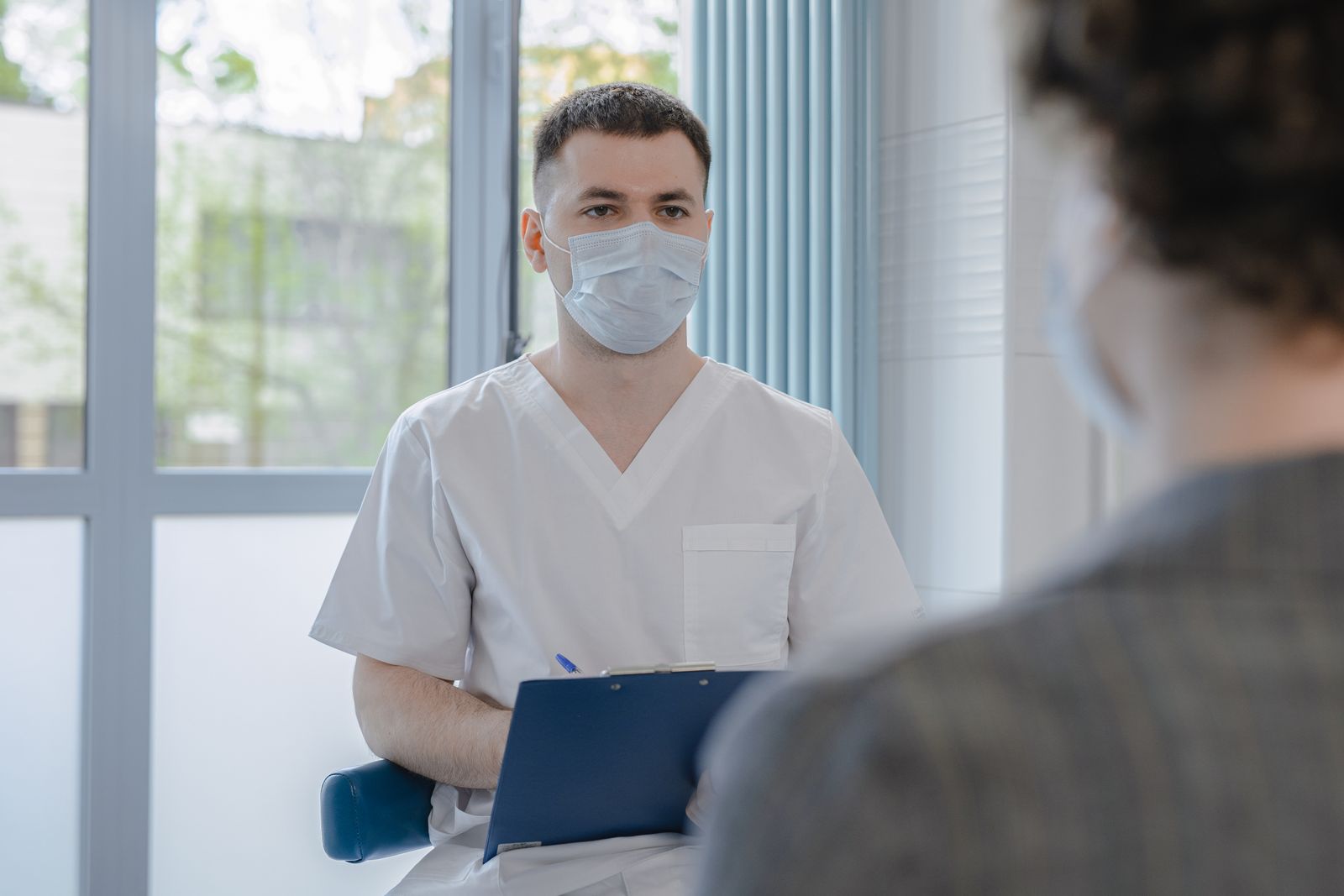 Single Port Robotic Surgery - doctor answering a patient's questions with a clipboard